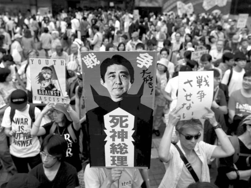 Hundreds of protesters joined a demonstration in Shibuya on Saturday against Mr Abe’s policies. Only 29 per cent of the public support the security Bills; 53 per cent oppose them. The centre placard reads in Japanese ‘Love the war’ (top) and ‘Reaper Prime Minister’ (bottom). Photo: Reuters