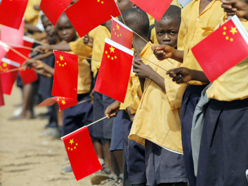 African children holding Chinese flags. President Xi Jinping ­ordered Chinese state companies in Africa to adopt extra measures aimed at protecting their workers after the Bamako tragedy in November last year. PHOTO: REUTERS