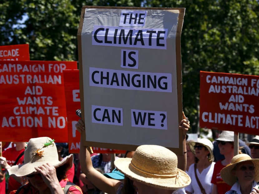 People hold placards and banners as they participate in a march ahead of the Paris World Climate Change Conference, along the main street of Adelaide, South Australia November 29, 2015.  Photo: Reuters