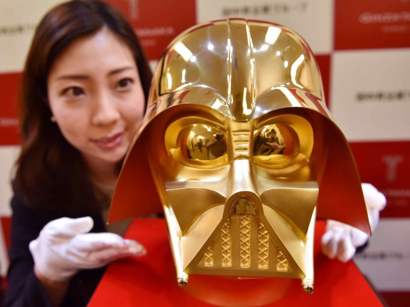 An employee of Japan's jeweler Tanaka Kikinzoku Jewelry displays a pure gold life size mask of Darth Vader, a character in the Star Wars, at their main shop in Ginza shopping district in Tokyo on April 25, 2017. The pure gold mask will go on sale on May 4 to commemorate the 40th anniversary of the movie. Photo: AFP