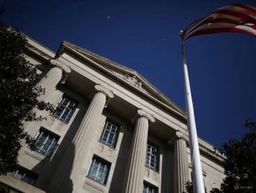FILE PHOTO: An American flag waves outside the U.S. Department of Justice Building in Washington, U.S., December 2, 2020. REUTERS/Tom Brenner/File Photo