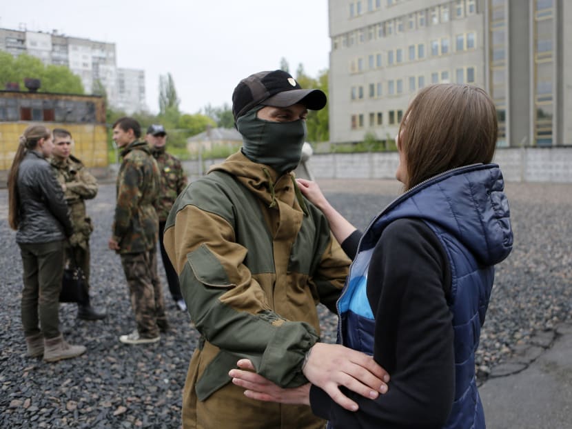 Friends and relatives say goodbye to volunteers being sent to the eastern part of Ukraine to join the ranks of special battalion "Azov" fighting against pro-Russian separatists, in Kiev, Ukraine, Thursday, May 7, 2015. Photo: AP