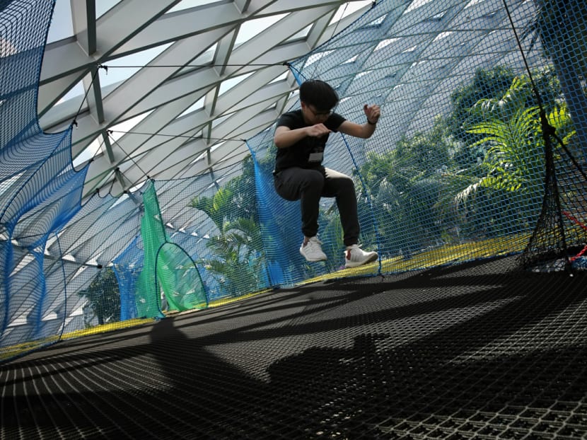 A visitor jumps on a giant bouncing net, during the media preview of Canopy Park and Changi Experience Studio at Jewel Changi Airport on May 30, 2019.