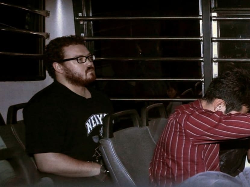 Rurik Jutting sitting in the back of a prison bus, along with suspects of other cases hiding their faces, as they arrive in the Eastern Law Courts in Hong Kong yesterday. Photo: Reuters