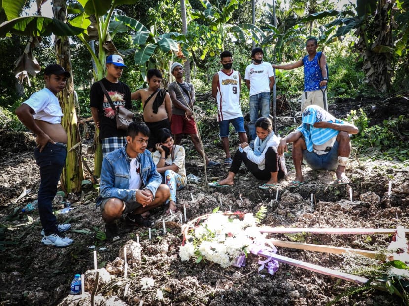 Relatives grieve at a mass burial site where the Sapi family buried seven of their members, victims of the landslide in the nearby village at the height of Typhoon Nalgae, in Datu Odin Sinsuat, Maguindanao, southern Philippines on Oct 31, 2022.
