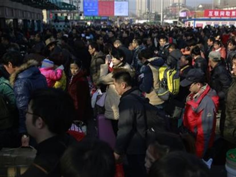 Chinese travellers queue up at the main entrance of the Beijing railway station in Beijing. Photo: AP