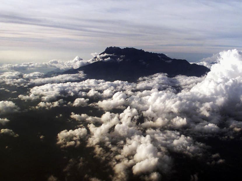 Mount Kinabalu appears through the clouds over Kota Kinabalu, capital of the east Malaysian state of Sabah on Borneo island, in this March 8, 2002 aerial photograph. Photo: Reuters
