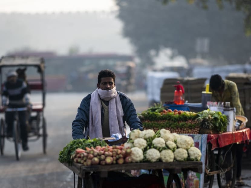 A vegetable vendor looks for customers along a street under smoggy conditions in New Delhi, India on Dec 4, 2020.