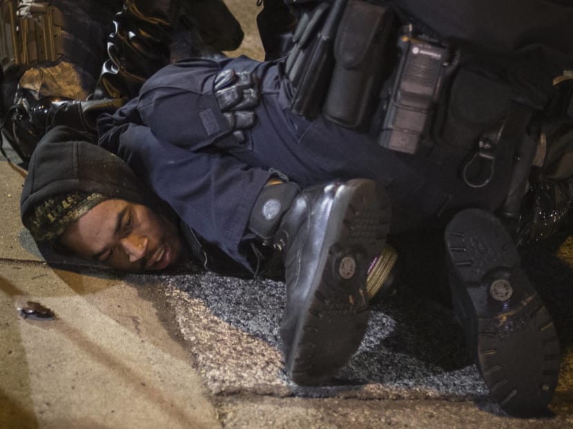 A policeman and member of the National Guard detain a man demanding justice for the killing of 18-year-old Michael Brown, outside the Ferguson Police Department in Missouri. Photo: Reuters