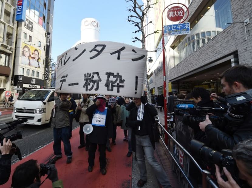 Ten protesters holding a banner saying "Smash Valentine's Day" march during a demonstration around the Shibuya shopping district in Tokyo on February 14, 2015. Photo: AFP
