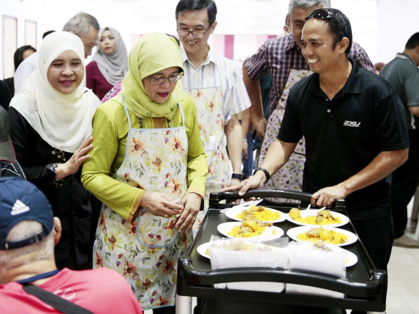 Mr Kahar Hassan (right) with Marsiling-Yew Tee MP Halimah Yacob (left) serving lunch yesterday at the Marsiling Kindness Project, which supports needy families. Photo: Jason Quah/TODAY
