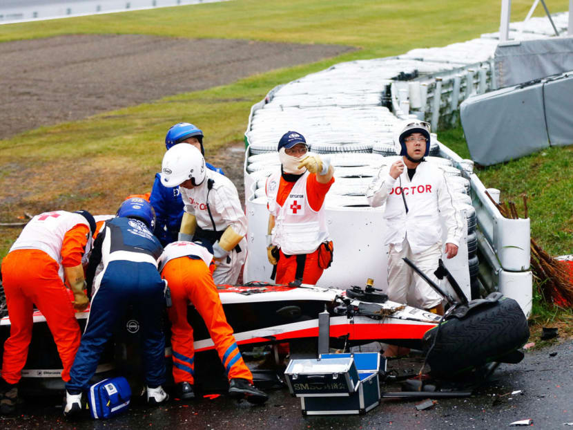 Bianchi receiving urgent medical treatment after crashing at the Japanese Grand Prix on Oct 5. The magnitude of the blow and the glancing nature of it caused massive head deceleration and angular acceleration, leading to his severe injuries. PHOTO: GETTY IMAGES
