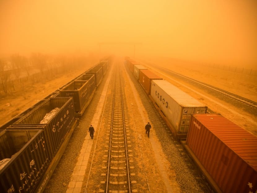This photo taken on March 21, 2023 shows police officers checking train cars at a border checkpoint during a sandstorm in the border city of Erenhot, in China's northern Inner Mongolia region.