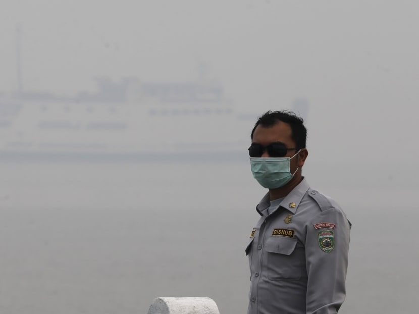 An Indonesian Transportation Department officer walks as the haze shrouds the Tanjung Siapi Api port in Palembang, Sumatra, on Sept 19, 2015. Photo: Reuters