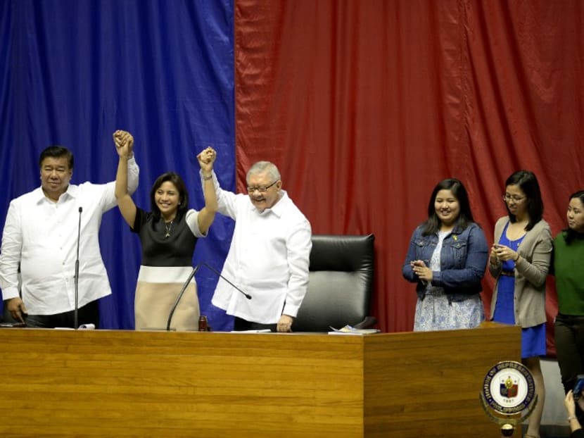 Philippine Senate president Frank Drilon (L) and House speaker Feliciano Belmonte (3rd L) raise the hands of vice president-elect Leni Robredo (2nd L) as Robredo's daughters Jessica Marie (3rd R), Janine Patricia (2nd R), and Jillian Therese (R) look on during Robredo's proclamation as vice president at the Session Hall of the House of Representatives in Manila on May 30, 2016. Rodrigo Duterte, the nation's next president, snubbed the high-profile event. Photo: AFP