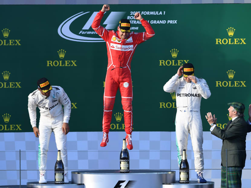 Ferrari's Sebastian Vettel (centre) celebrates on the podium, beside second-plaved Mercedes' British driver Lewis Hamilton (left) and third-placed Mercedes' Finnish driver Valtteri Bottas. Photo: AFP