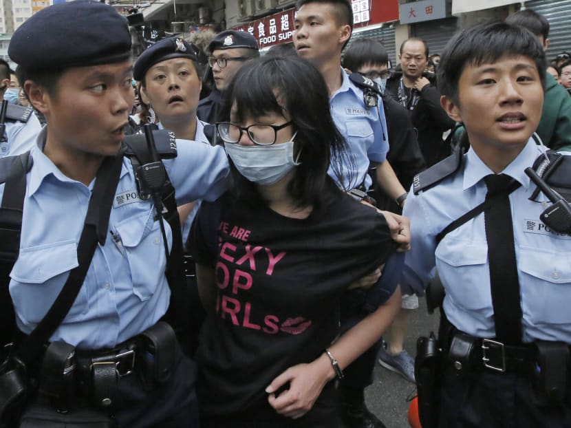 A protester is taken away by police officers after the confrontation between activists demonstrating against mainland Chinese shoppers and local villagers at a  suburban district of Yuen Long in Hong Kong today (March 1, 2015). Photo: AP