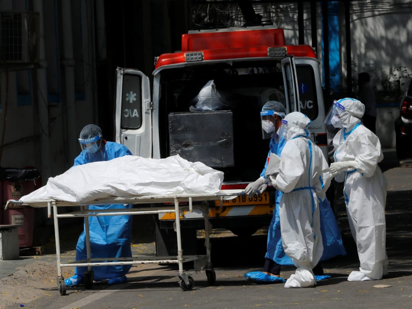 Mortuary workers load the body of a person who died from Covid-19 to an ambulance for cremation, at a hospital in New Delhi, India on May 5, 2021. Mortuary workers load the body of a person who died from Covid-19 to an ambulance for cremation, at a hospital in New Delhi, India on May 5, 2021.