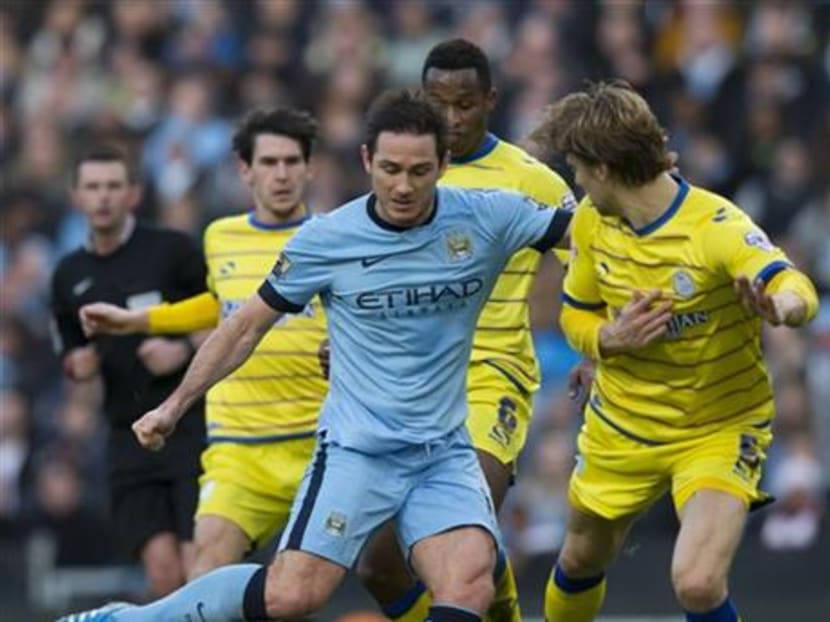 Manchester City's Frank Lampard, centre left, attempts to take the ball past Sheffield Wednesday's Glenn Loovens, right, during their English FA Cup third round soccer match at the Etihad Stadium, Manchester, England, Jan 4, 2015. Photo: AP