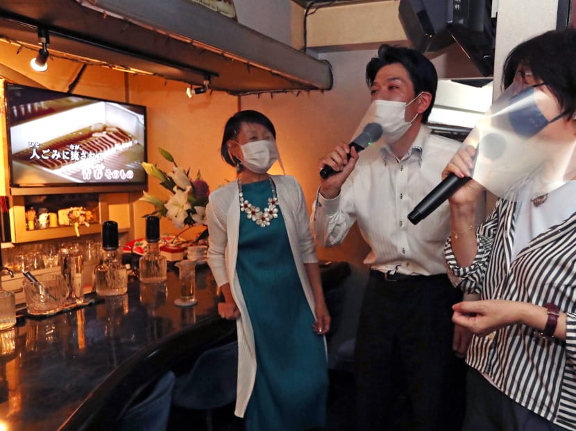People wearing face shield and mask sing karaoke at a bar in Nagoya City, Aichi Prefecture on June 1, 2020.