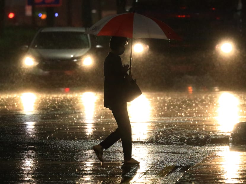 A woman crosses a road in the rain on Aug 30, 2021 in Singapore.
