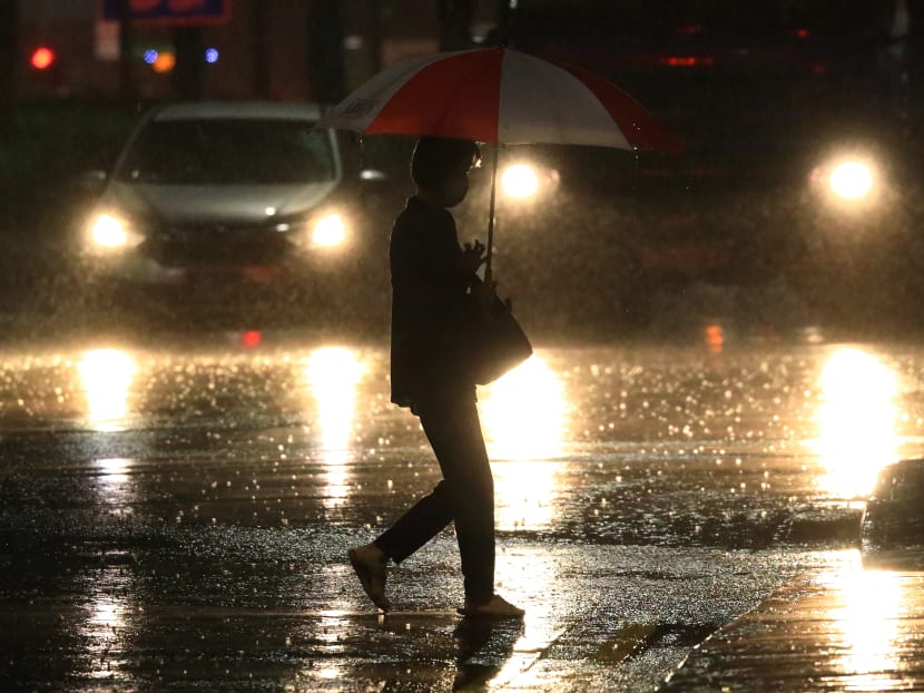 A woman crosses a road in the rain on Aug 30, 2021 in Singapore. A woman crosses a road in the rain on Aug 30, 2021 in Singapore.