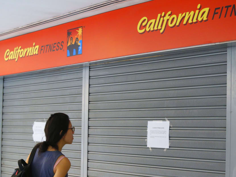 A member of the public reads the closure notice outside California Fitness. Photo: Ernest Chua