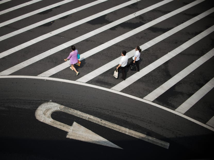 People cross a street in the Lujiazui Financial District of Pudong, Shanghai. Photo: AFP