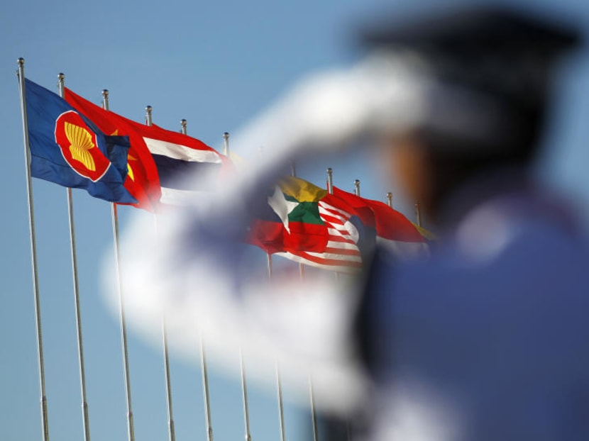 A police officer stands near national flags of Asean counties flags during the an earlier ASEAN Summit. Reuters file photo