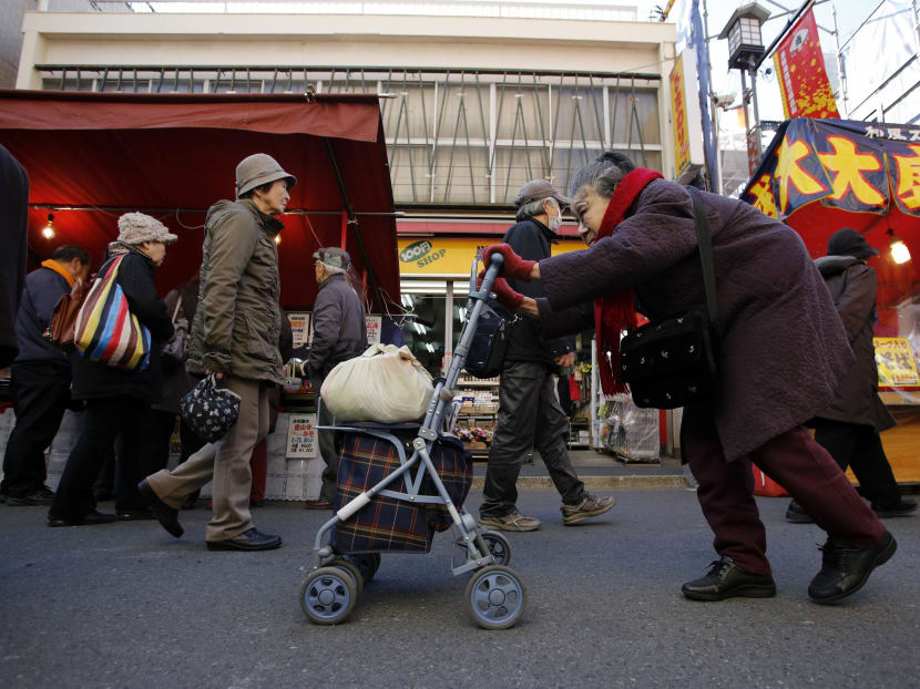 An elderly woman pushes a walking aid as she walks on a street at Tokyo's Sugamo district, an area popular among the Japanese elderly, in Tokyo on Jan 14, 2015. Reuters file photo