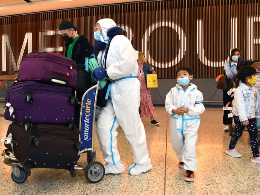International travellers wearing personal protective equipment arrive at Melbourne's Tullamarine Airport on Nov 29, 2021 as Australia records its first cases of the Omicron variant of Covid-19.