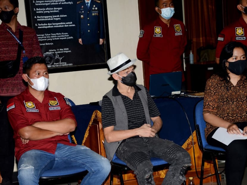 This picture taken on May 9, 2021 shows Christopher Kyle Martin of Canada seated during a press conference by immigration authorities at the international airport near Denpasar before his flight out of Indonesia's resort island of Bali, after he was expelled for offering an orgasmic yoga class which was considered disrespectful for local traditions and values.
