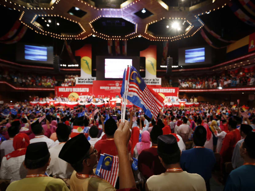 UMNO members waves flags as they sing parties song during the opening ceremony of Malaysia's ruling party UMNO 68th General Assembly in Kuala Lumpur, Malaysia yesterday. Photo: AP