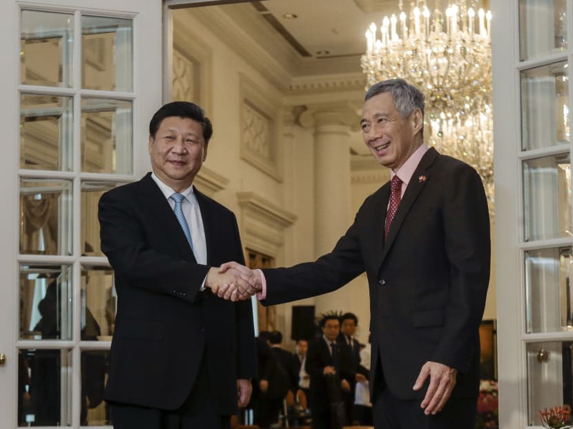 PM Lee Hsien Loong and Chinese President Xi Jinping shake hands at the Istana. AP file photo