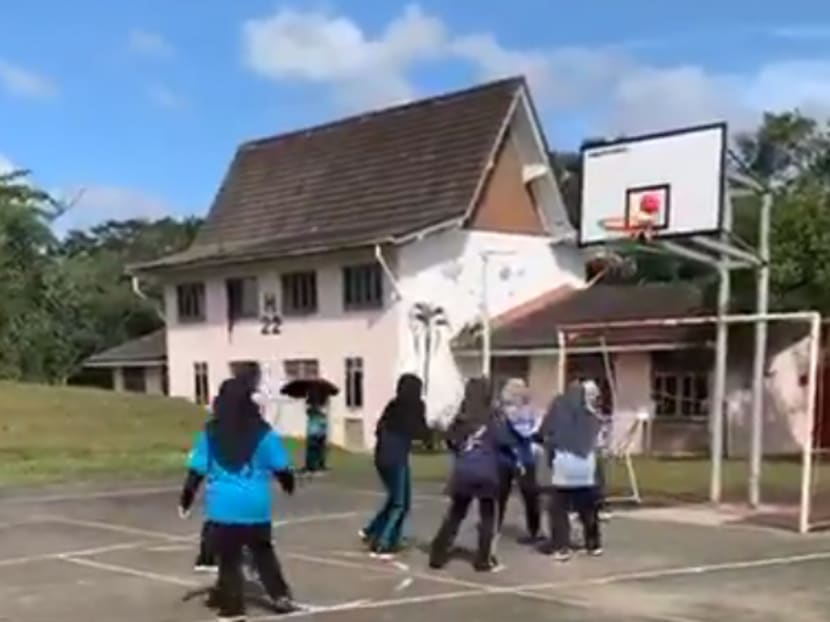 A group of young girls watched on as their teammate unwittingly scooped their futsal ball into the basketball hoop.