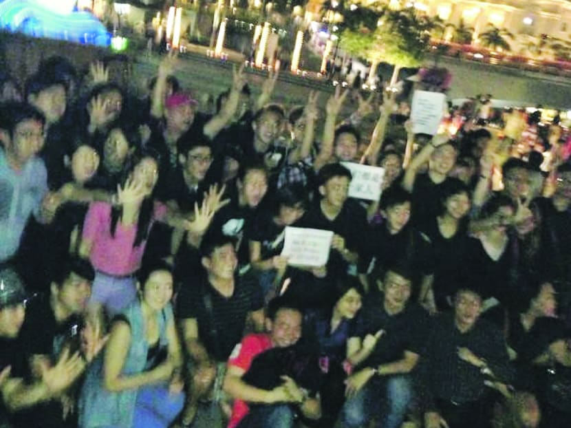 A group dressed in black gathered near the Merlion last night, holding placards with messages about the Malaysian elections. Photo: Earlson Siew
