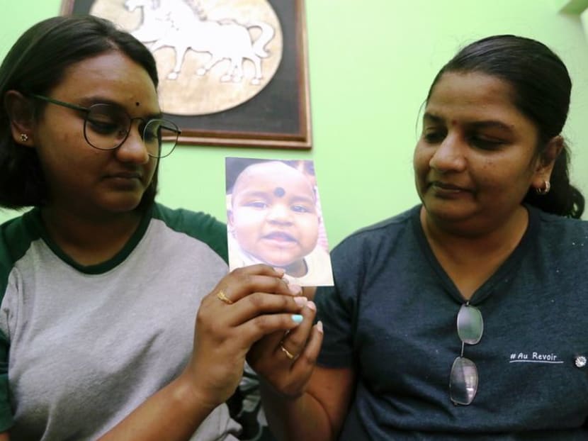 Ms M. Indira Gandhi (right) looking at a picture of her youngest daughter, Prasana Diksa, whom she has not seen for nine years. Photo: The Malay Mail Online