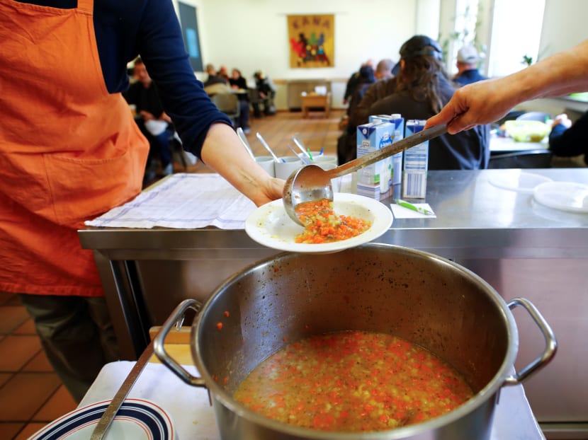 Volunteers dish out vegetable soup for people in need at the soup kitchen "Kana" in a poor district of the city of Dortmund, western Germany.