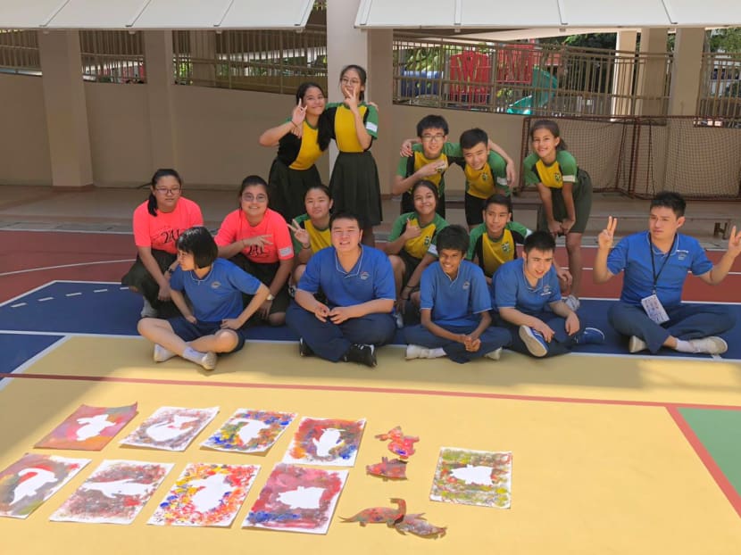 Students from Orchid Park Secondary School (second and third row) spending time with special needs students at Rainbow Centre — Yishun Park School to paint and do activities together. Rainbow Centre — Yishun Park School is one of six schools that will lower their fees for Singaporean students from January 2020.