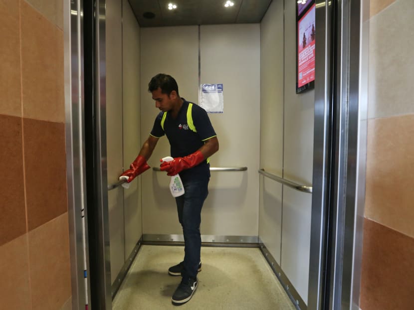A cleaner wiping the handlebars in a lift at Blk 842 Tampines St 82 on March 8, 2020.