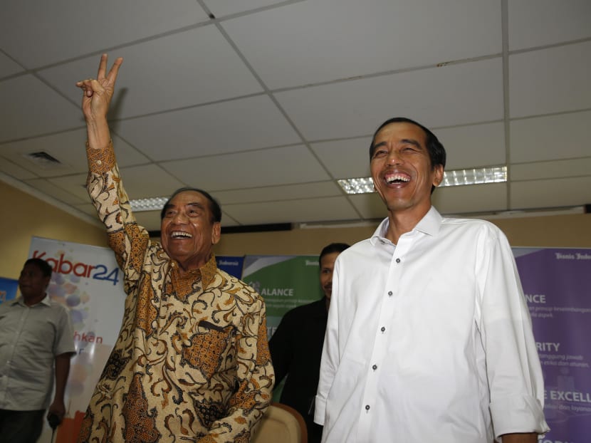Jakarta governor Joko Widodo (right) smiles as Mr Sukamdani Gitosardjono, the owner of the Bisnis Indonesia newspaper, shouts a slogan in Jakarta, July 21, 2014. Photo: Reuters