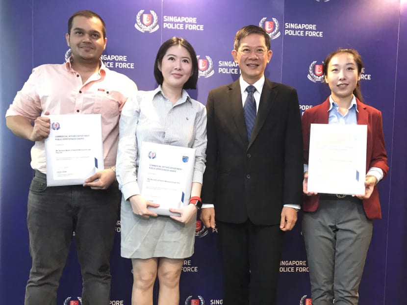 Three members of the public, Mr Sameer Malik and Ms Novianti of Samlit Moneychanger and Ms Li Fang of Zhongguo Remittance, received the Public-Spiritedness Award from CAD director David Chew at the Police Cantonment Complex. Photo: Wong Pei Ting/TODAY