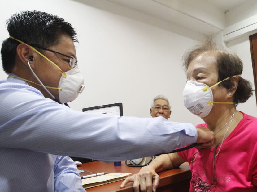 General practitioner Dr Tan with an elderly patient. Photo: Ernest Chua