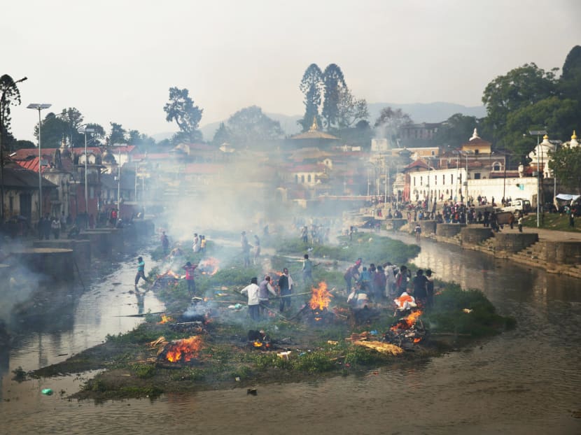 Flames rise from funeral pyres during the cremation of victims of Saturday’s earthquake at the Pashuputi Nath Temple on the banks of Bagmati River in Kathmandu on Sunday. Well over 1,000 of the victims were in Kathmandu, where an eerie calm prevailed yesterday. Photo: AP