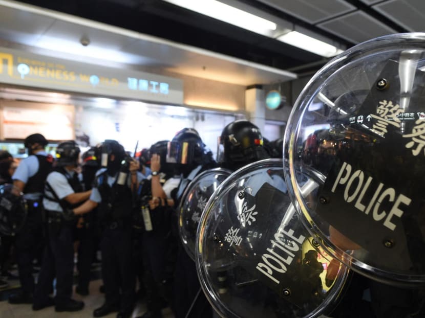 Police stand guard during a protest at the New Town Plaza shopping mall in Shatin, Hong Kong, in December 2019.
