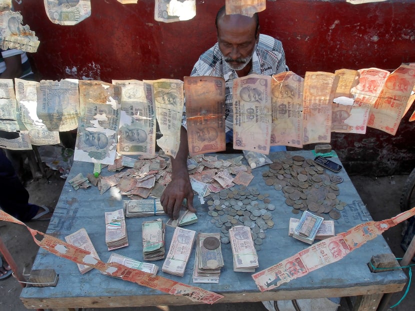 A roadside currency exchange vendor sorts Indian currency notes at his stall in Agartala, India, December 6, 2016. Source: Reuters