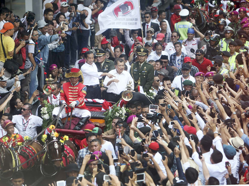 President Joko Widodo gesturing to the crowd during a street parade following his inauguration in Jakarta yesterday. Photo: Jakarta globe