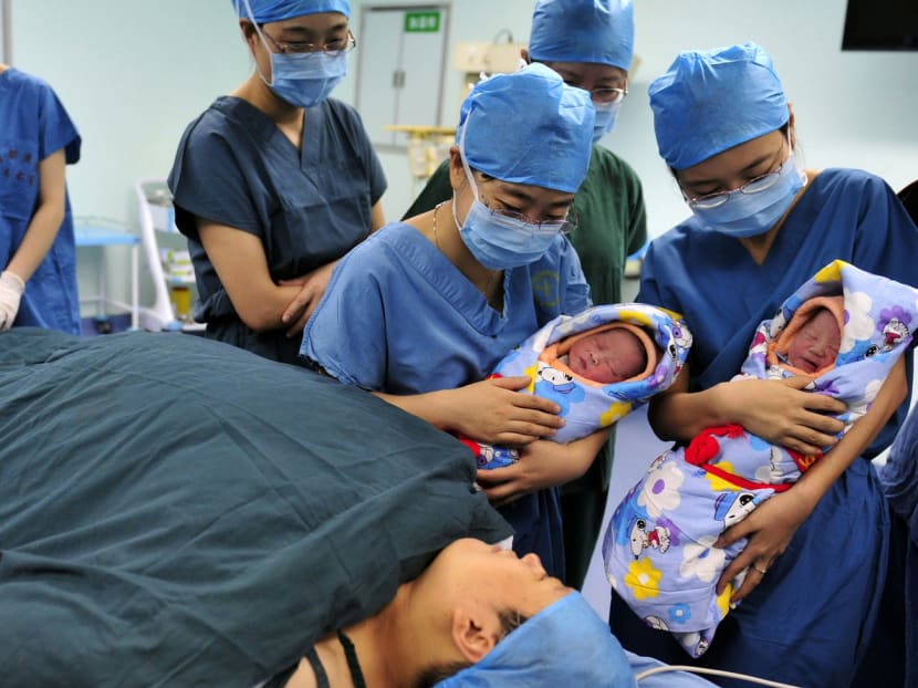Nurses holding a pair of fraternal twins to their mother after they were born at a hospital’s IVF centre in Xi’an, Shaanxi province. With China having relaxed its strict one-child policy, the assisted reproductive health market could potentially be worth around S$21 billion. Photo: Reuters