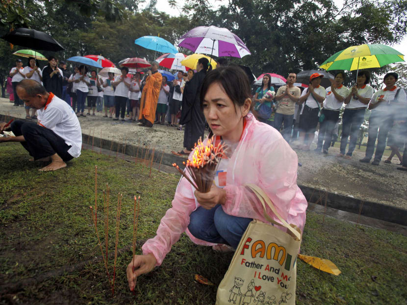 An Indonesian Buddhist woman light incense sticks during a prayer for the victims of Indian Ocean tsunami one day ahead of its 10th anniversary at a mass grave in Banda Aceh, Aceh province, Indonesia,  Dec 25, 2014.  Photo: AP