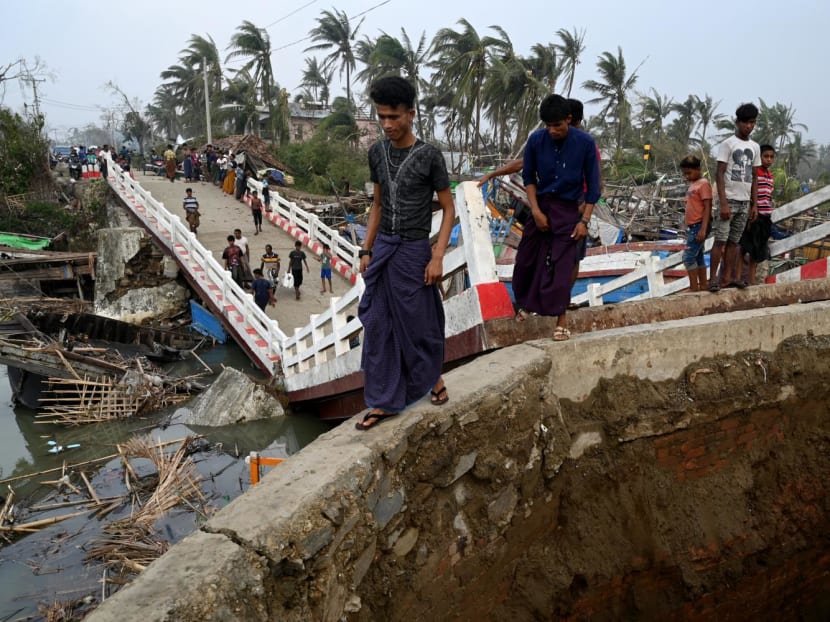 People cross a broken bridge at the Khaung Dote Khar Rohingya refugee camp in Sittwe, Myanmar, on May 15, 2023, after cyclone Mocha made a landfall.